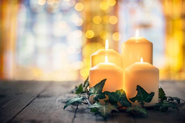 Candles burning in a church background Candles burning in a church with stained glass window background burning candle stock pictures, royalty-free photos & images